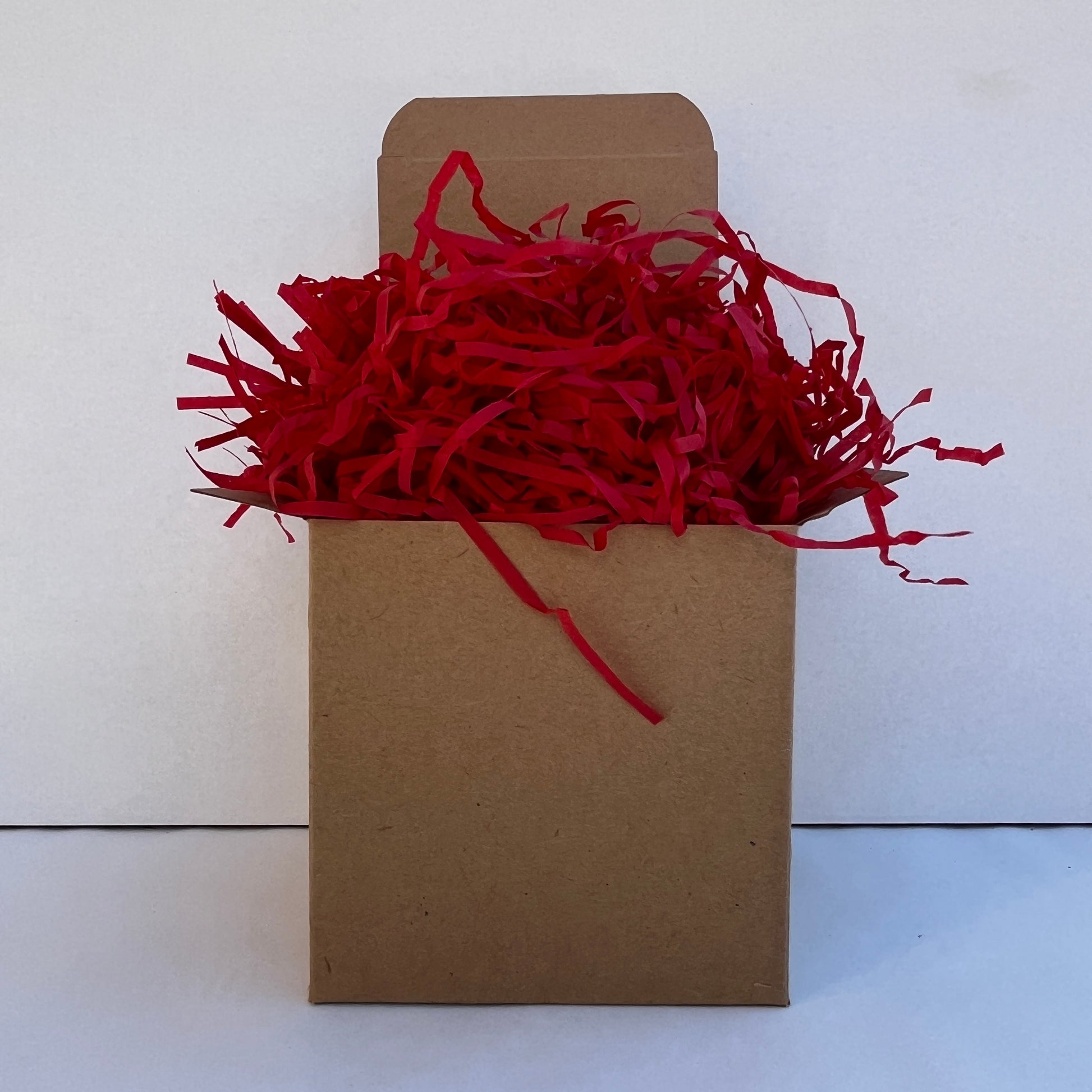 Red shredded paper in gift box packaging eco friendly filler