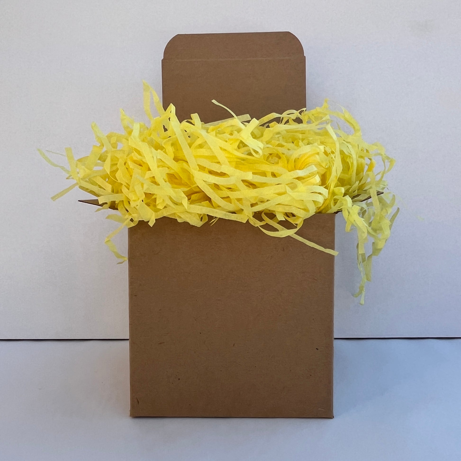 Yellow shredded paper in gift box packaging eco friendly filler